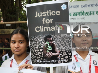 School students form a human chain and hold a poster during a Global Climate Strike march in Kolkata, India, on September 27, 2024. (