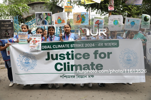 School students form a human chain and hold posters during a Global Climate Strike march in Kolkata, India, on September 27, 2024. 