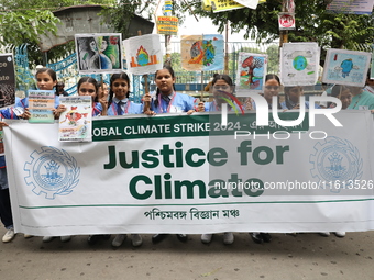 School students form a human chain and hold posters during a Global Climate Strike march in Kolkata, India, on September 27, 2024. (