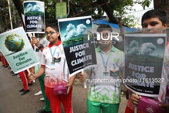 School students form a human chain and hold posters during a Global Climate Strike march in Kolkata, India, on September 27, 2024. 