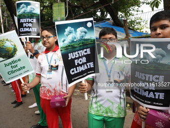 School students form a human chain and hold posters during a Global Climate Strike march in Kolkata, India, on September 27, 2024. (