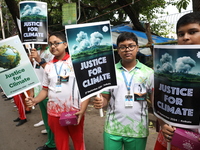 School students form a human chain and hold posters during a Global Climate Strike march in Kolkata, India, on September 27, 2024. (