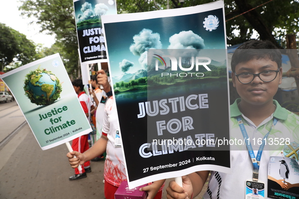 School students form a human chain and hold posters during a Global Climate Strike march in Kolkata, India, on September 27, 2024. 