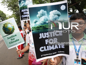 School students form a human chain and hold posters during a Global Climate Strike march in Kolkata, India, on September 27, 2024. (