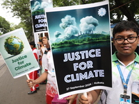 School students form a human chain and hold posters during a Global Climate Strike march in Kolkata, India, on September 27, 2024. (