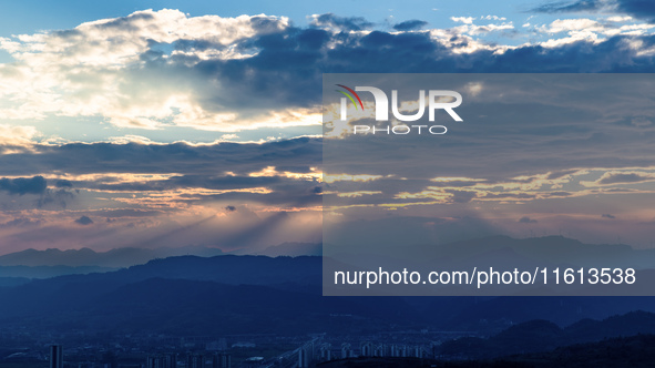 View of the morning light pouring through clouds on a distant mountain in Chongqing, China, on September 27, 2024. 