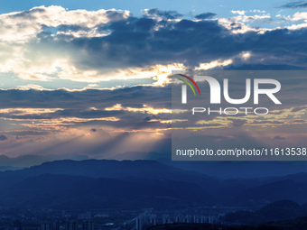 View of the morning light pouring through clouds on a distant mountain in Chongqing, China, on September 27, 2024. (