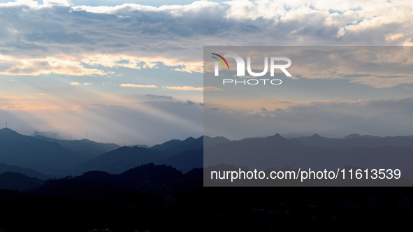 View of the morning light pouring through clouds on a distant mountain in Chongqing, China, on September 27, 2024. 