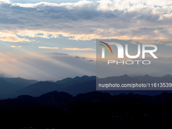 View of the morning light pouring through clouds on a distant mountain in Chongqing, China, on September 27, 2024. (