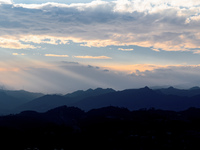 View of the morning light pouring through clouds on a distant mountain in Chongqing, China, on September 27, 2024. (