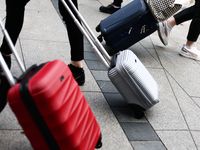 People walk with suitcases in Krakow, Poland on September 26, 2024. (