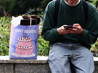 A person uses a phone as a birthday gift bag is seen in Krakow, Poland on September 26, 2024. (