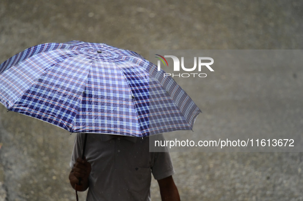 A pedestrian travels in heavy rainfall with an umbrella in Kirtipur, Kathmandu, Nepal, on September 27, 2024. 