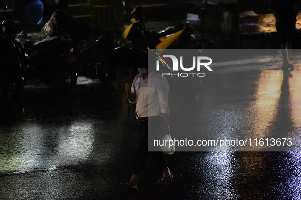 A pedestrian travels in heavy rainfall with an umbrella in Kirtipur, Kathmandu, Nepal, on September 27, 2024. 