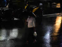 A pedestrian travels in heavy rainfall with an umbrella in Kirtipur, Kathmandu, Nepal, on September 27, 2024. (