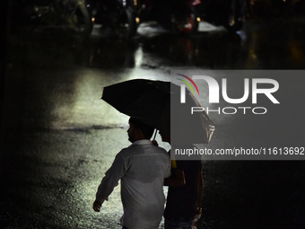 A pedestrian travels in heavy rainfall with an umbrella in Kirtipur, Kathmandu, Nepal, on September 27, 2024. (