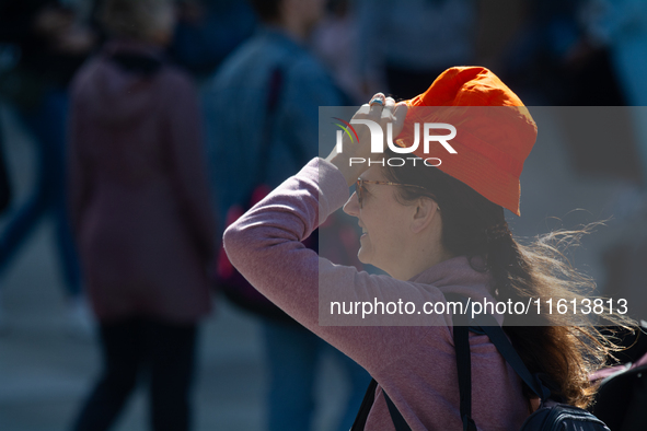 A woman struggles to walk on a windy day in Cologne, Germany, on September 27, 2024. 