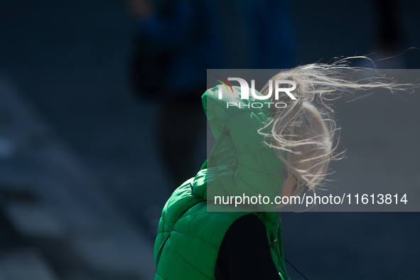 A woman struggles to walk on a windy day in Cologne, Germany, on September 27, 2024. 