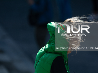 A woman struggles to walk on a windy day in Cologne, Germany, on September 27, 2024. (