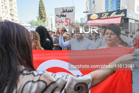 A demonstrator raises a placard that reads in Arabic, ''Down with the 54 July system,'' during a demonstration organized by the Tunisian Net...