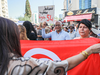 A demonstrator raises a placard that reads in Arabic, ''Down with the 54 July system,'' during a demonstration organized by the Tunisian Net...