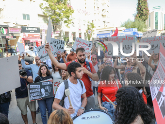 Tunisians shout slogans and raise placards during a demonstration organized by the Tunisian Network for Rights and Freedoms near the Assembl...