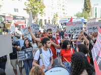 Tunisians shout slogans and raise placards during a demonstration organized by the Tunisian Network for Rights and Freedoms near the Assembl...