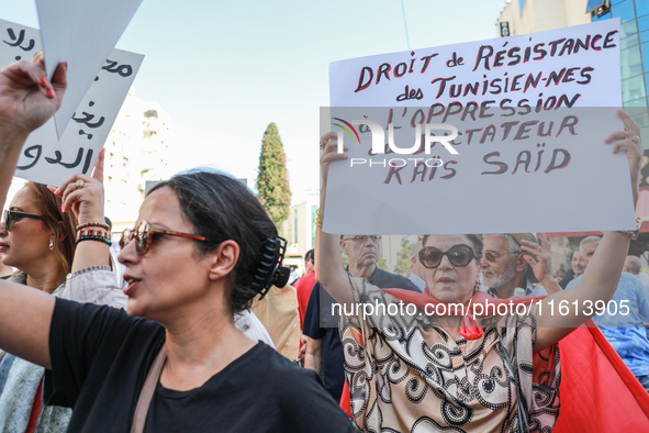 A female demonstrator raises a placard that reads, ''Tunisians' right to resist the oppression of dictator Kais Saied,'' during a demonstrat...