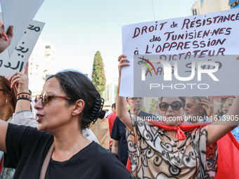 A female demonstrator raises a placard that reads, ''Tunisians' right to resist the oppression of dictator Kais Saied,'' during a demonstrat...