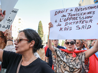 A female demonstrator raises a placard that reads, ''Tunisians' right to resist the oppression of dictator Kais Saied,'' during a demonstrat...