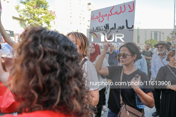 A female demonstrator raises a placard that reads in Arabic, ''No to life-long rule, Parliament of the coups,'' during a demonstration organ...