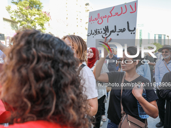 A female demonstrator raises a placard that reads in Arabic, ''No to life-long rule, Parliament of the coups,'' during a demonstration organ...