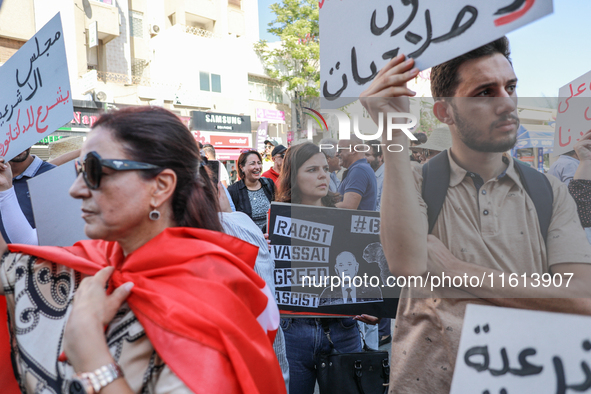 A female demonstrator holds a placard with a caricature of Tunisian president Kais Saied that reads, ''racist, vassal, greed, fascist,'' dur...