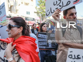 A female demonstrator holds a placard with a caricature of Tunisian president Kais Saied that reads, ''racist, vassal, greed, fascist,'' dur...