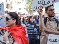 A female demonstrator holds a placard with a caricature of Tunisian president Kais Saied that reads, ''racist, vassal, greed, fascist,'' dur...