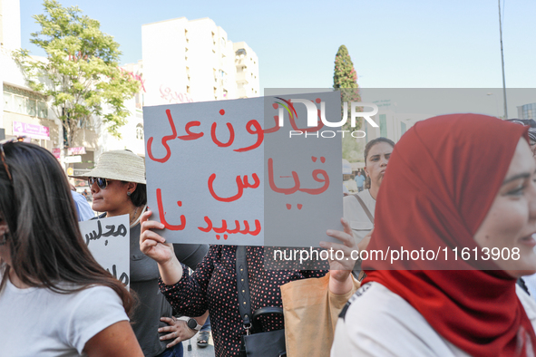 A demonstrator holds a placard that reads in Arabic, ''a law tailored to the President,'' during a demonstration organized by the Tunisian N...