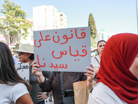 A demonstrator holds a placard that reads in Arabic, ''a law tailored to the President,'' during a demonstration organized by the Tunisian N...