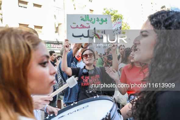 A female demonstrator raises a placard that reads in Arabic, ''President of the Parliament on demand,'' during a demonstration organized by...