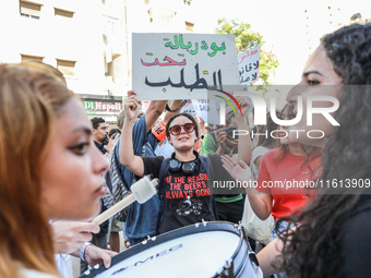 A female demonstrator raises a placard that reads in Arabic, ''President of the Parliament on demand,'' during a demonstration organized by...