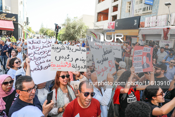 Tunisians shout slogans and raise placards during a demonstration organized by the Tunisian Network for Rights and Freedoms near the Assembl...