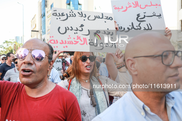 A female demonstrator shouts slogans as she raises a placard that reads in Arabic, ''a Parliament without legitimacy, at the disposal of the...