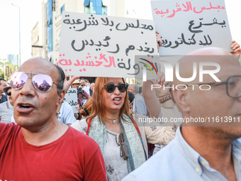 A female demonstrator shouts slogans as she raises a placard that reads in Arabic, ''a Parliament without legitimacy, at the disposal of the...