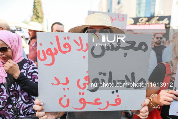 A female demonstrator raises a placard that reads in Arabic, ''a lawless Parliament at the mercy of pharaoh,'' during a demonstration organi...