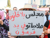 A female demonstrator raises a placard that reads in Arabic, ''a lawless Parliament at the mercy of pharaoh,'' during a demonstration organi...