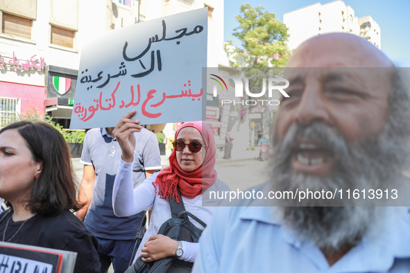 A female demonstrator raises a placard that reads in Arabic, ''The Parliament of illegitimacy legalizes dictatorship,'' during a demonstrati...