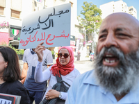 A female demonstrator raises a placard that reads in Arabic, ''The Parliament of illegitimacy legalizes dictatorship,'' during a demonstrati...