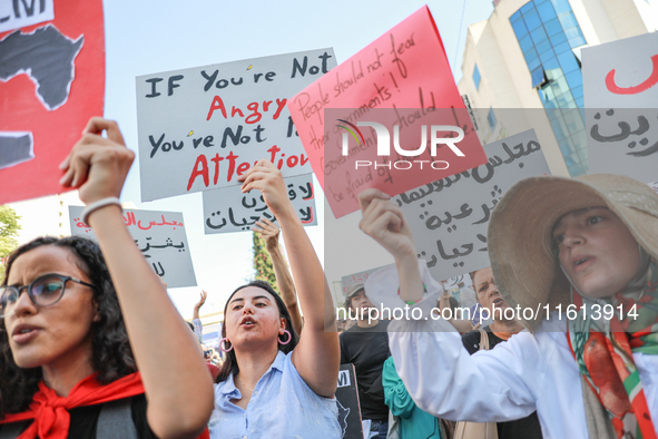 Demonstrators shout slogans and raise a placard that reads, ''If you are not angry, you are not paying attention,'' during a demonstration o...