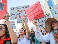 Demonstrators shout slogans and raise a placard that reads, ''If you are not angry, you are not paying attention,'' during a demonstration o...