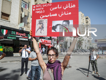 A female demonstrator holds up a placard with photos of sub-Saharan African migrants who die in the desert during a demonstration organized...