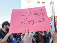 A demonstrator holds a placard that reads in Arabic, ''theatrical elections,'' during a demonstration organized by the Tunisian Network for...